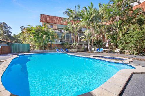 a swimming pool in front of a building at Hawaiian Gardens 17 in Coffs Harbour