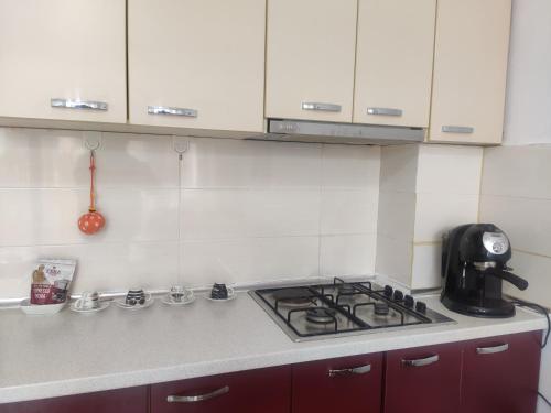a kitchen counter with a stove top and white cabinets at Sunny Side Apartment Shkoder Albania in Shkodër