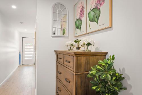 a room with a wooden dresser with flowers on it at Gorgeous 4 Bedroom House - Blackmans Bay in Kingston Beach