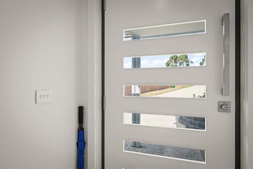 a white door with a window in it at Gorgeous 4 Bedroom House - Blackmans Bay in Kingston Beach