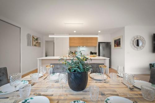 a dining room table with a plant on top of it at Gorgeous 4 Bedroom House - Blackmans Bay in Kingston Beach