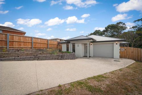 a house with a fence and a driveway at Gorgeous 4 Bedroom House - Blackmans Bay in Kingston Beach