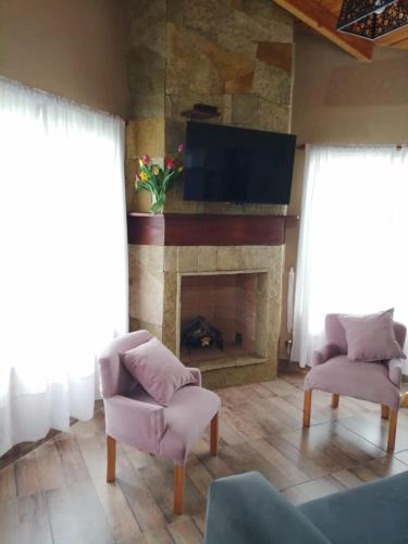 a living room with a fireplace and a tv at Rincón Bonito in El Hoyo