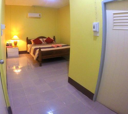a bedroom with a bed in a room with yellow walls at Khao Chang View Resort in Phangnga