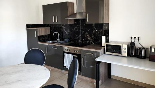 ホーフハイム・アム・タウヌスにあるHotel Valley of Business Frankfurt-Airport - GREY LABEL APARTMENTのキッチン(電子レンジ、テーブル付きのカウンター付)
