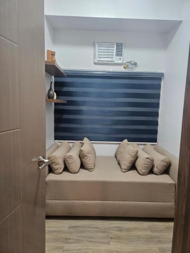 a couch with pillows on it in a room at 2Br QC Furnished Condo w 300mbps Net Free Pool Use in Manila