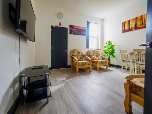 a living room with a tv and a table and chairs at Chatham Lodge Family Room 2 Ensuite in Stoke on Trent