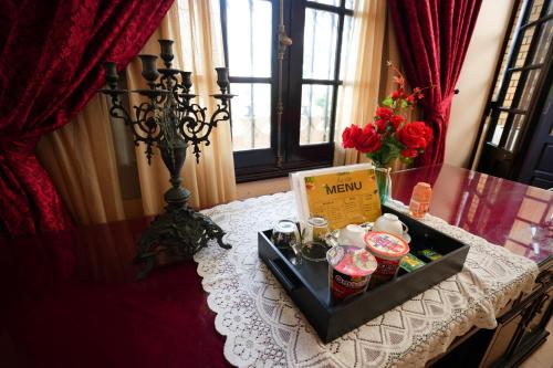 a table with a tray of food and flowers on it at Perfume Homestay Huế in Hue