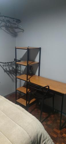 a wooden table and a chair next to a desk at Recanto Arvoredo casa 3 quartos piscina garagem e NF para 12 hospedes in Concordia