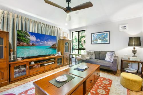 a living room with a large flat screen tv at Korora Coastal Escape in Kororo Basin