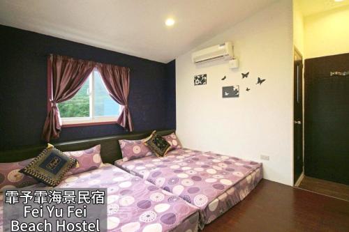 a bedroom with a bed with pink pillows and a window at Fei Yu Fei Beach Hostel in Lanyu