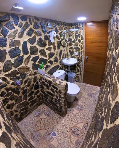a stone bathroom with a toilet and a sink at CASA LOMA BEACH LOFT in Taganga
