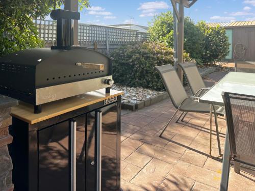 a grill sitting on a table on a patio at Ocean Breeze - Sleeps 12 - Pet Friendly in Scamander