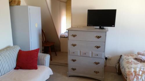 a bedroom with a dresser with a tv on top at Rowlands Castle No 41 in Rowlands Castle