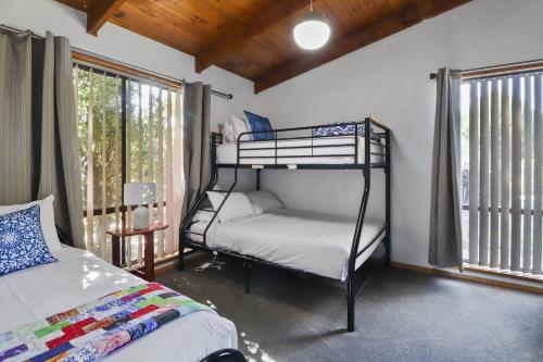 a bedroom with two bunk beds and a window at Ocean Breeze - Sleeps 12 - Pet Friendly in Scamander