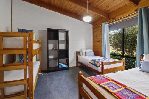 a bedroom with two bunk beds and a balcony at Ocean Breeze - Sleeps 12 - Pet Friendly in Scamander