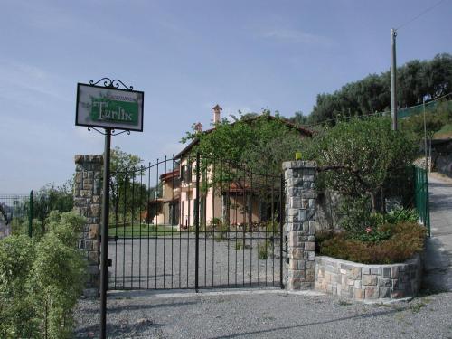 a sign in front of a gate with a house at Agriturismo Turlin in Vallebona