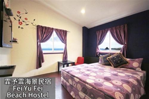 LanyuFei Yu Fei Beach Hostel的带一张床和两扇窗户的卧室