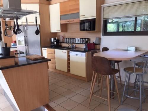 une cuisine avec un comptoir et une table à l'intérieur dans l'établissement Villa Lacanau Evasion, à Lacanau-Océan