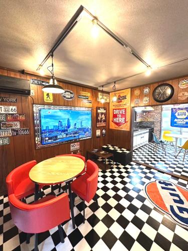 a dining room with a table and chairs and a tv at 無料駐車場有り 新大阪駅まで1駅1分 Guest House 橘 東三国,最大12名,最寄り駅まで徒歩5分,2階建て貸切 in Osaka