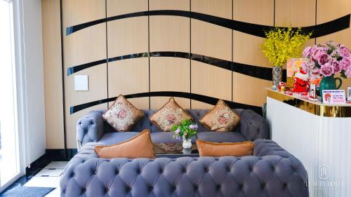 a blue couch with pillows on it in a room at Luxury Sunset Town Hotel Phu Quoc in Phu Quoc