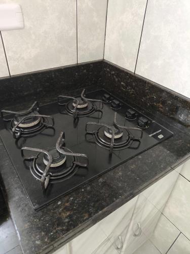 a stove top in a kitchen with a black counter top at CASA OT ESTRELA - Climatização, churrasqueira e piscina in Três Lagoas