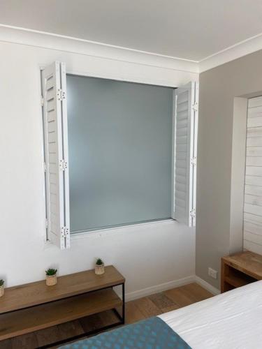 a bedroom with a large window in the wall at Ocean Front Motel in The Entrance