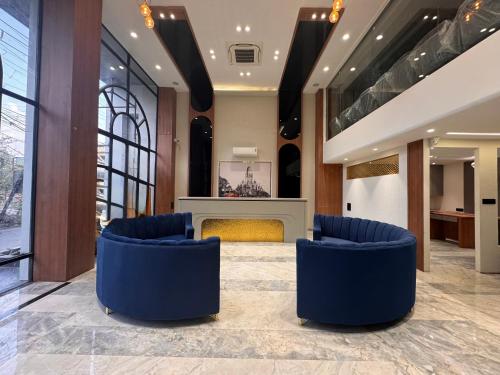 a lobby with blue chairs and a fireplace at Hotel Mumbai House Vijay Nagar Nr Brilliant Convention Center in Indore
