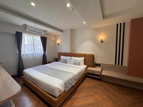 a bedroom with a large bed and a window at Hotel Mumbai House Vijay Nagar Nr Brilliant Convention Center in Indore