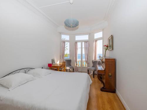 une chambre avec un lit, un bureau et des fenêtres dans l'établissement Appartement 4 pers à Menton, 60 m² - FR-1-196-378, à Menton