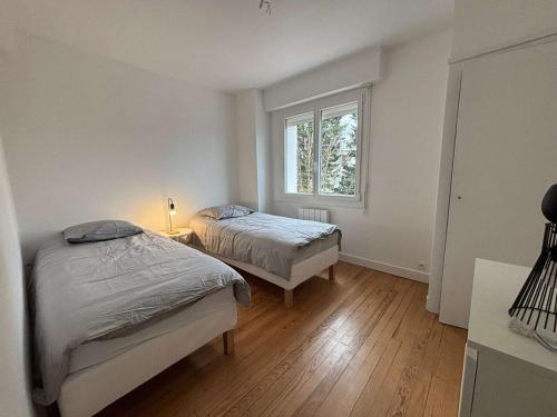 une chambre avec deux lits et une fenêtre dans l'établissement Bel appartement refait à neuf proche plage Royan - FR-1-494-209, à Royan