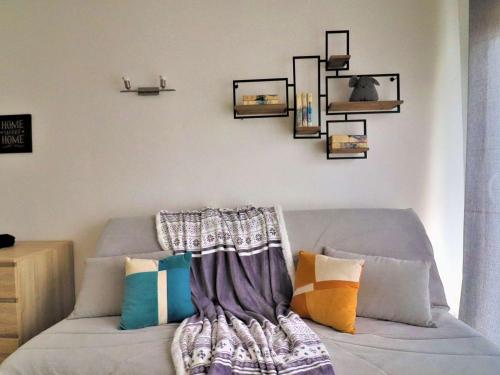 - un canapé avec des oreillers dans l'établissement Appartement rénové avec terrasse à Royan - FR-1-494-206, à Royan