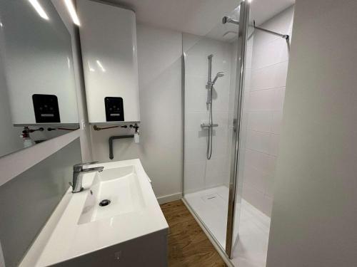 une salle de bain blanche avec une douche et un lavabo dans l'établissement Bel appartement refait à neuf proche plage Royan - FR-1-494-209, à Royan