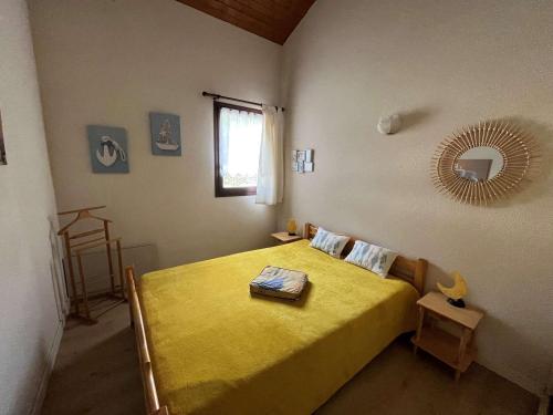 - une chambre avec un lit jaune et un miroir dans l'établissement Appartement charmant proche plage et parking - FR-1-494-208, à Vaux-sur-Mer