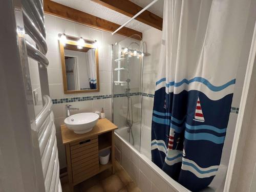 une salle de bain avec un lavabo et un rideau de douche dans l'établissement Appartement charmant proche plage et parking - FR-1-494-208, à Vaux-sur-Mer