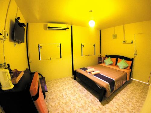 a bedroom with a large bed in a yellow room at Khao Chang View Resort in Phangnga