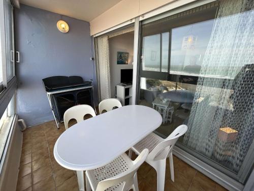 une table blanche et des chaises dans une pièce avec une fenêtre dans l'établissement Appartement 2 pièces avec parking à Saint-Jean-de-Monts - FR-1-224C-346, à Saint-Jean-de-Monts