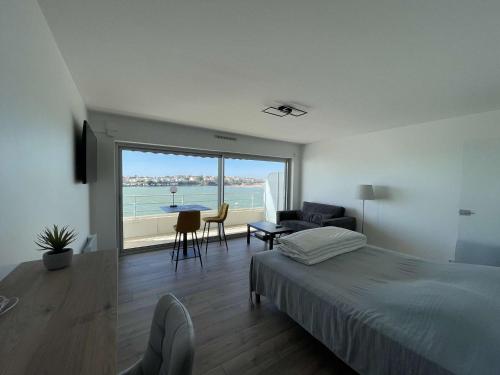 une chambre avec un lit et une vue sur l'océan dans l'établissement Studio neuf avec terrasse sur mer et garage à Royan - FR-1-494-207, à Royan