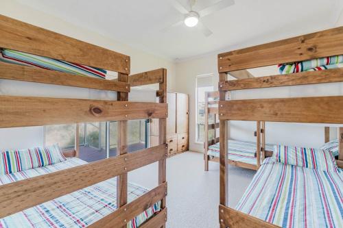 a room with three bunk beds in a house at Bradford Shores Goolwa - Luxury - Wi-Fi - No Linen Included in Goolwa