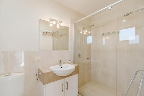 a white bathroom with a sink and a shower at Bradford Shores Goolwa - Luxury - Wi-Fi - No Linen Included in Goolwa