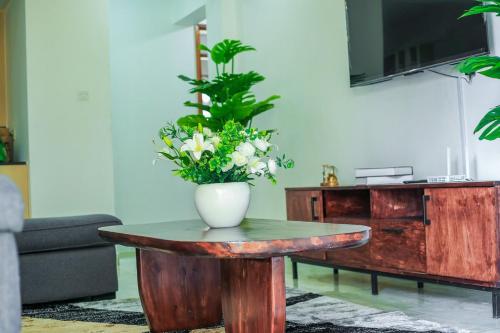 a vase of flowers on a table in a living room at Stylish 3-bed Ensuite Apt in Westlands in Nairobi