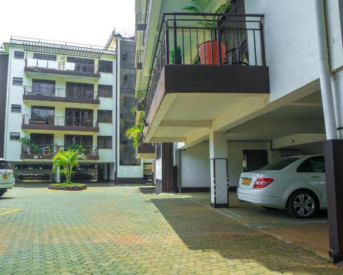 a car parked in a parking lot next to a building at Stylish 3-bed Ensuite Apt in Westlands in Nairobi