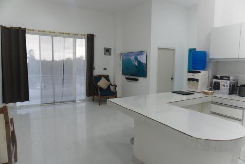 a kitchen with a white counter top and a tv at Apartamento Ciudad del Surf Montañita in Montañita