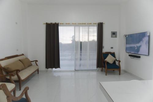 a living room with a couch and a tv at Apartamento Ciudad del Surf Montañita in Montañita