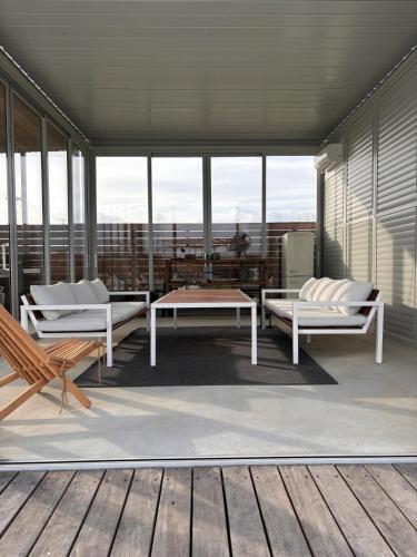 a room with two benches and a table on a balcony at VILLA Seamu 海風とどく広々贅沢GARDEN エアコン付きBBQルームを備えた高級ヴィラ in Kujukuri