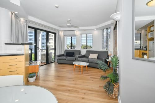 a living room with a couch and a table at Aegean Dream Mooloolaba Escape in Mooloolaba
