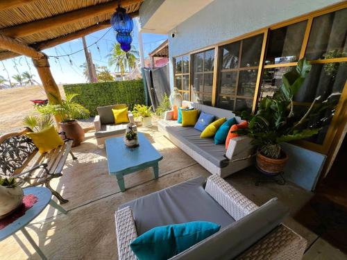 a patio with couches and a table and potted plants at Casa Punta Perula Boutique Hotel in Pérula