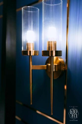 a pair of lights on a blue wall at เลอค่าเชียงแสน Le Quar Cafe BistroBed & Breakfast in Golden Triangle