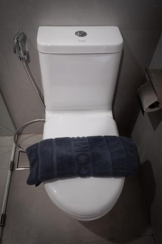 a black towel sitting on a toilet in a bathroom at Near Don Mueang Hotel in Don Muang Airport