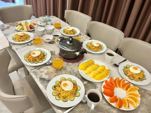 岘港Luxury Dana Beach Resort & Spa的桌子上摆满了早餐食物